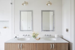 The updated master bathroom includes a double vanity with a Calacatta Michelangelo marble countertop with chrome plumbing fixtures from Waterworks Easton.