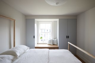 Custom closets painted Benjamin Moore Sterling were added to both kids' bedrooms. One room has a built-in window seat (pictured) and the other has a built-in desk.