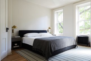 The updated master bedroom includes new crown molding. The former closet was removed where the left nightstand is now located; the closet door was reused for the family room on the ground floor.