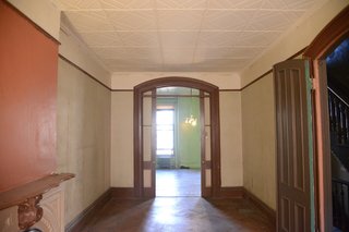 Located to the left of the entry hall, the living room felt disjointed with walls painted in a variety of different colors.