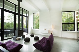 The living room is anchored by a wood-burning stove. The sofas in this room are by Ligne Roset.