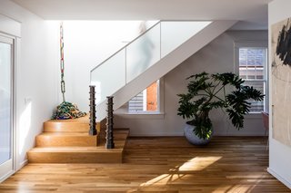 The new staircase was installed next to old windows on the east wall, and ascends to a light-filled hall above.
