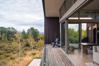 The covered porch wraps around the east and south sides of the home to overlook Teton views, as well as the pond and creek.