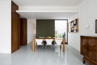 Since the apartment is located on the first level, part of the floor plan was carved out to serve as two ventilation pits for the upper-floor bathrooms and kitchens. The architects strategically decided to turn these spaces into small gardens.