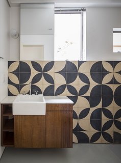 Local artist Teo Menna designed the pattern for the bathroom cement tile. "It is an old material that refers back to the time of the construction of the building, but was used with a more contemporary language," note the architects.