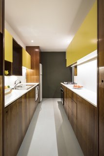 A glimpse into the remodeled kitchen with Silestone countertops and backsplashes paired with cabinetry built of lacquered MDF and Imbuia wood.