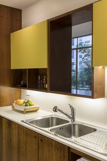 An opening above the double sink frames views of the tree canopy.