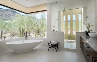 A freestanding soaking tub in the master bath is perfectly placed beneath a corner window shaded by the roof overhang.