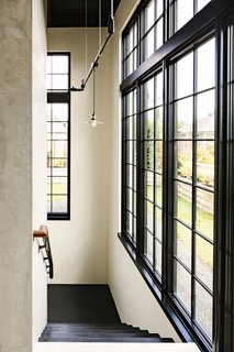 Stairs lead down to a the ground floor that houses a guest apartment, a two-car garage, and a weight room.