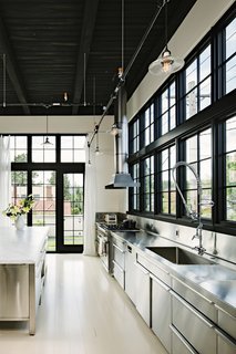 Stainless steel has been used for the kitchen counters, cabinets, and backsplash.