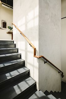 The light-filled stair wraps around a primitive factory elevator shaft.