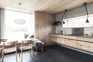 A muted and natural material palette of stone, timber, metal, and glass define the interiors. The floors are locally-mined Caithness stone, installed with radiant underfloor heating.