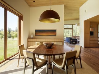 The dining room is furnished with Holly Hunt tables and chairs. Mammalampa's Queen Pendant lamp hangs above.