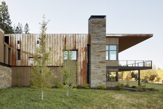 The residence is clad in a combination of vertical grain cedar, Firestone aluminum, and Corten standing-seam metal. The stone is Frontier Sandstone.