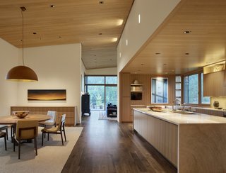 The open kitchen is fitted with Perla Venato Quartzite countertops and timber cabinetry.