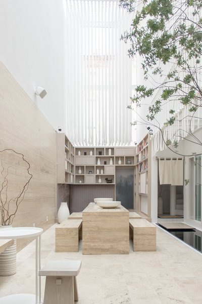 The light-filled welcome area features an open library, seating, and a zen garden.