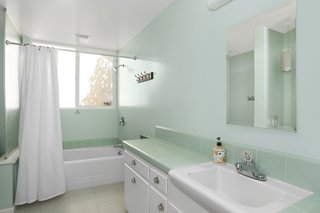 The kids' bathrooms have new flooring, yet maintain the original fixtures and tiles.