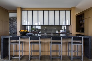 BDDW bar stools are combined with a waterfall-edge Aged Petite Granit kitchen island.
