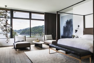 Bathed in natural light, the master bedroom with a Holly Hunt walnut bed commands impressive views of the bay. The hanging art is by Kibong Rhee.