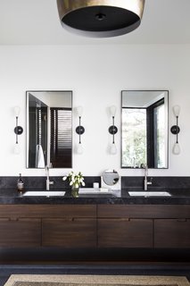 The master bath is fitted with custom teak cabinetry and Aged Petit Granit counters.