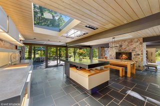 A double fireplace separates the kitchen and dining space from the living area located on the split level below.