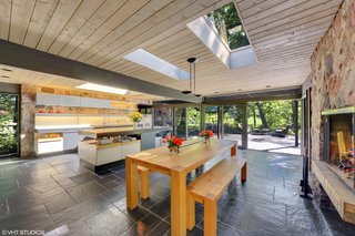 Natural black clefted slate flooring continues from the entrance foyer to the open kitchen and dining area.