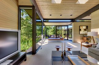The residence mitigates the slope with split-level organization. The living room and media room (pictured here) are located a few steps down from the kitchen and dining area on the ground floor.