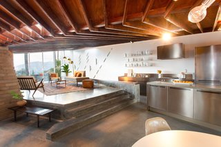 The raised living room steps down to the eat-in kitchen. Polished concrete floors are used throughout.