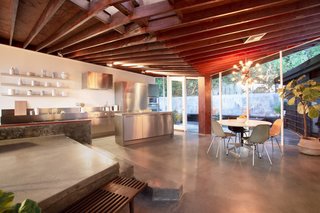 The kitchen features updated appliances, stainless steel countertops, and a poured concrete island.