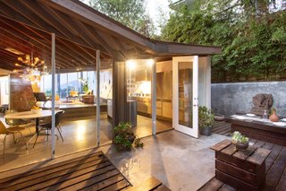 The kitchen opens up to a rear timber patio that's enclosed with bamboo and concrete walls.