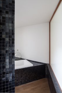 A peek inside a mosaic-tiled bathroom with a soaking tub.