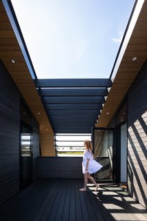 A south-facing view of the exterior deck on the second floor that links the living spaces with the studio.