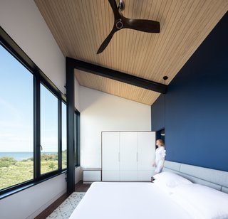 The master bedroom overlooks views of the water and beach through continuous glazing.
