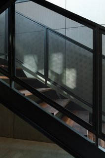 The staircase features walnut treads and black steel railings.