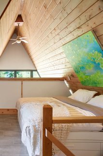 Bathed in natural light, the upstairs master bedroom overlooks views of the living space below.
