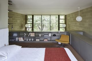 Guardrail-high bookcases provide storage and a sense of enclosure from the living area below.