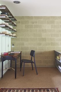 The L-shaped bedroom accommodates a private workspace around the corner.