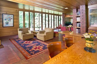 Full-height glazed doors flood the interior with natural light and open up to an outdoor brick terrace.