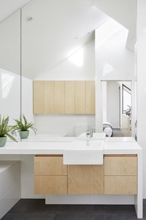 The master bath is outfitted with a Caesarstone "Snow" countertop and hoop pine plywood cabinetry.