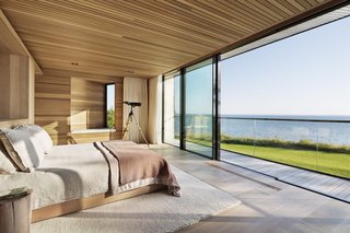 Bathed in light, the master bedroom overlooks stunning waterfront views.