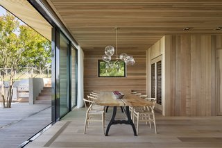 Sliding doors provide a seamless connection between the dining room and the outdoor dining and kitchen areas.