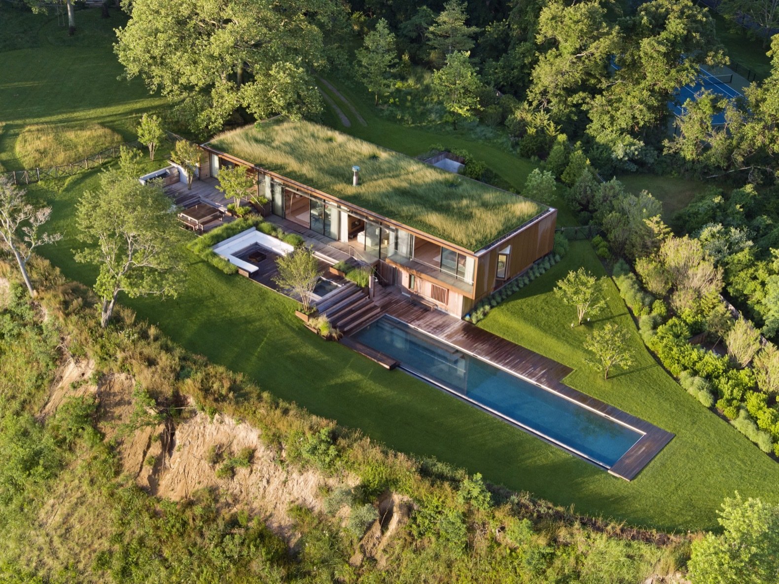 The home is located far from the road on the northwest corner of the property and oriented toward views of the water.