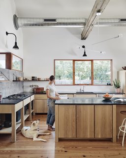 Here, Sarah and their dog, Mandy, are seen in the kitchen. The counters are soapstone and the cabinets stained white oak.