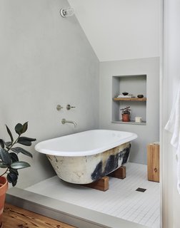The clawfoot tub was a salvaged find, while reclaimed wood was used for the shelving.