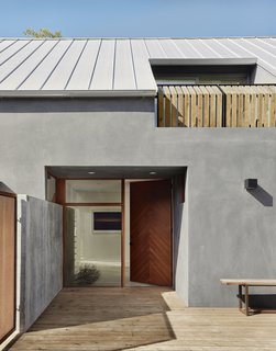 The entrance is located to the side of the house. The recessed Douglas fir front door was built by Austin’s Honea Woodworks. The roof is Galvalume standing-seam metal.