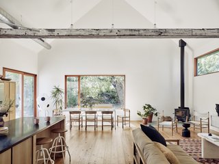 The double-height living space is anchored by a wood-burning stove by Lopi in the corner. The large east-facing window on the far wall floods the room with magical morning light. All the windows and doors are by Quantum.