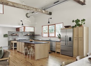 The floors in the open-plan living area, kitchen, and dining area are reclaimed longleaf pine. The ceiling beams are also salvaged pine.