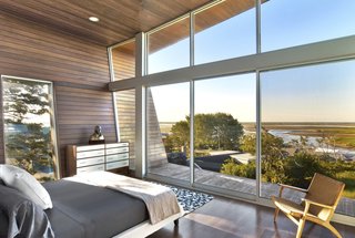 Ipe wood envelopes the master bedroom that overlooks spectacular views of the beach through a wall of glass.