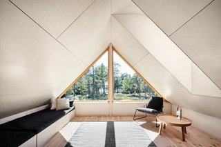 A small loft space sits above the living room and overlooks views of the forest and sea.