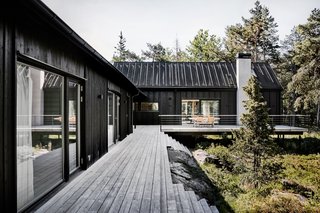 Pictured on the left is the former cottage that's located on the north side of the house. It houses two bedrooms, a kitchenette, dining area, bathroom, and a mud room.